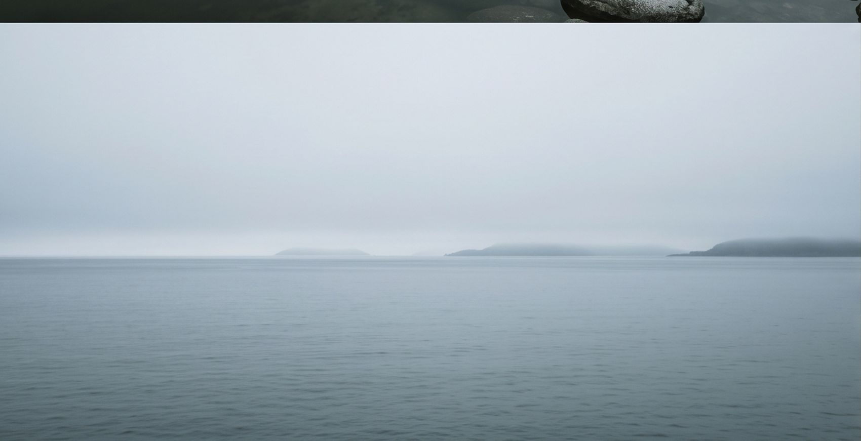 Une étendue d'eau calme sous un ciel de brume